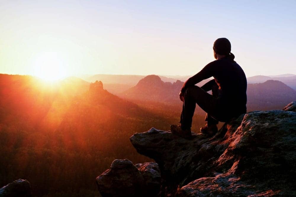 man gazing at mountain sunset