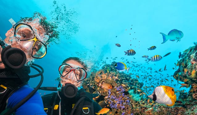 two divers under the sea posing for the camera new experience